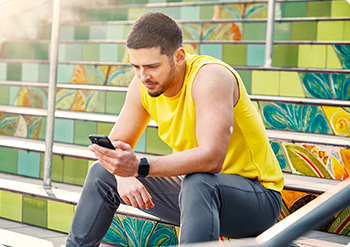 Man looking at his FreeStyle Libre 2 reader while working in a workshop