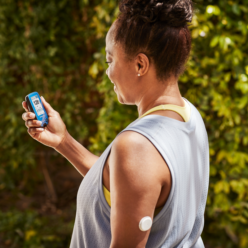 Woman wearing a FreeStyle Libre sensor checking her glucose on her reader