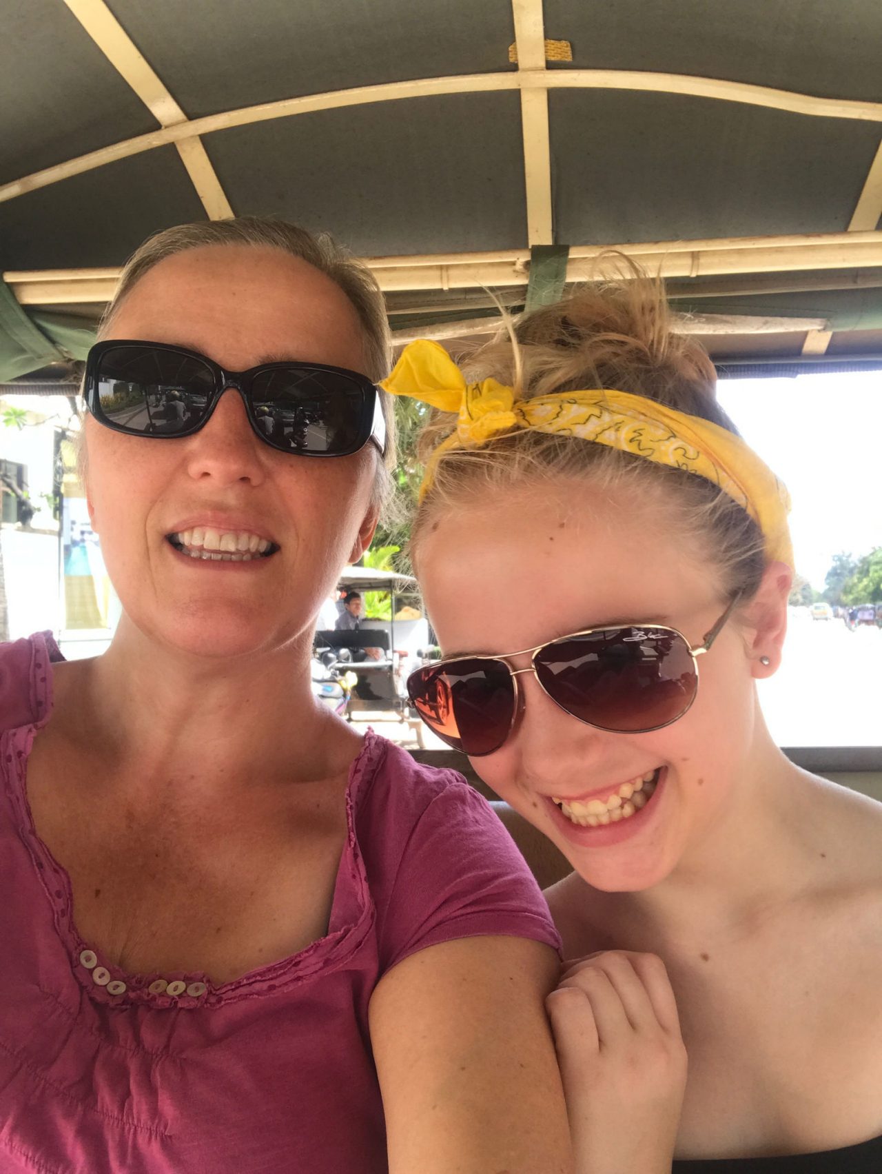Mother and daughter taking a selfie smiling and wearing sunglasses