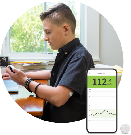 Teenage boy wearing a FreeStyle Libre continuous glucose monitoring (CGM) sensor